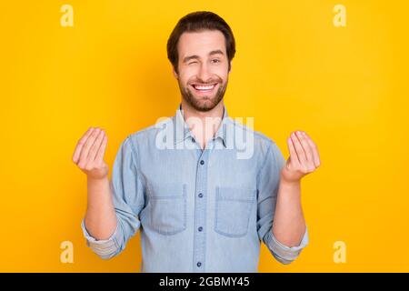 Ritratto fotografico di giovane ragazzo sorridente chiedendo soldi winking positivo isolato su sfondo giallo luminoso Foto Stock