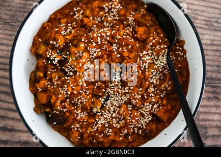 melanzane vegane e curry di lenticchie rosse con condimento dei semi di sesamo, ricette salutari a base di piante Foto Stock