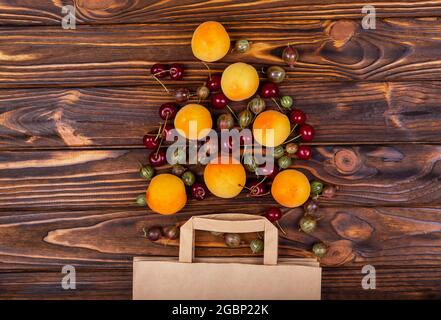 Acquisti alimentari online. Frutta in sacchetto di carta su sfondo di legno. Foto Stock