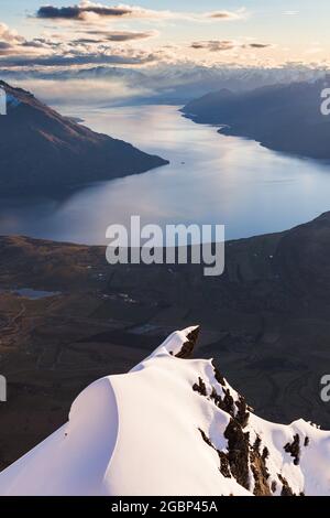 Un dito di roccia coperto di neve punta verso Queenstown e il lago Wakatipu, Queens Drive, Remarkables, Nuova Zelanda Foto Stock