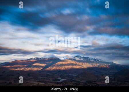 Lunga esposizione di nube che passa sopra la cima dei Remarkables, bacino di Wakatipu, Queenstown, Nuova Zelanda Foto Stock