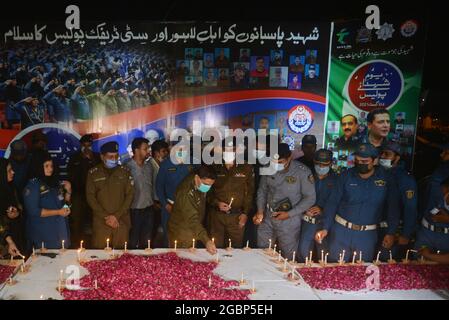 Lahore, Pakistan. 04 agosto 2021. Capo responsabile del traffico (CTO) Muntazir Mehdi, CCPO Ghulam Muhammad Dogar, DIG Imran, funzionari della polizia stradale delle donne e altri accendi le candele durante una cerimonia a lume di candela in occasione della "Giornata nazionale dei martiri della polizia" nel ricordo dei martiri della polizia del Punjab, Che hanno dato la vita per la pace nel paese" a Lahore. (Foto di Rana Sajid Hussain/Pacific Press/Sipa USA) Credit: Sipa USA/Alamy Live News Foto Stock