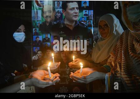 Lahore, Pakistan. 04 agosto 2021. Capo responsabile del traffico (CTO) Muntazir Mehdi, CCPO Ghulam Muhammad Dogar, DIG Imran, funzionari della polizia stradale delle donne e altri accendi le candele durante una cerimonia a lume di candela in occasione della "Giornata nazionale dei martiri della polizia" nel ricordo dei martiri della polizia del Punjab, Che hanno dato la vita per la pace nel paese" a Lahore. (Foto di Rana Sajid Hussain/Pacific Press/Sipa USA) Credit: Sipa USA/Alamy Live News Foto Stock