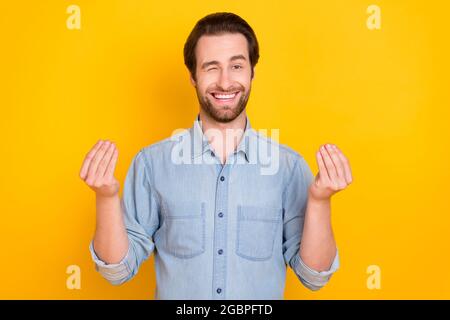 Ritratto fotografico di giovane ragazzo sorridente chiedendo soldi winking positivo isolato su sfondo giallo luminoso Foto Stock