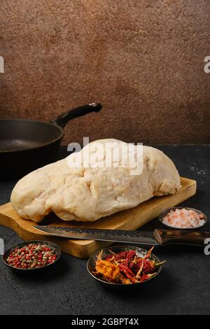 Coda di grasso di agnello sul tavolo da cucina con sale e pepe Foto Stock