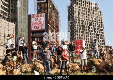 Beirut, Libano, 4 agosto 2021. Le persone che protestano per il fallimento di trovare i responsabili del Beirut Blast e li tengono responsabili un anno dopo l'enorme esplosione devastata la loro capitale si trovano di fronte a edifici ancora non riparati. Foto Stock