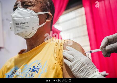 Kendari, Indonesia. 05 agosto 2021. Un disabile è visto essere iniettato con il vaccino Sinovac, Covid-19 presso lo stand di vaccinazione nella stazione di polizia di Mandonga. La cabina di Kendari per i vaccini della polizia ha organizzato un'operazione di vaccinazione per i disabili presso la stazione di polizia di Mandonga a Kendari. Decine di persone disabili sono state raccolte presso le loro rispettive case utilizzando i veicoli operativi della polizia per la loro prima dose del vaccino Sinovac, Covid-19. (Foto di Andry Denisah/SOPA Images/Sipa USA) Credit: Sipa USA/Alamy Live News Foto Stock