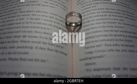 anello che riflette un cuore sul libro. Foto Stock