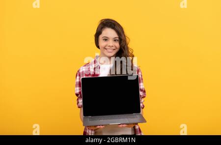 presentazione scolastica su computer. capretto pronto per la lezione video. ragazza teen con il laptop sulla testa. Foto Stock