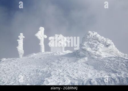 Paesaggio di alte montagne. Costruzione in cotto di neve e attraversare su un prato innevato. Nebbia sullo sfondo. Paesaggio naturale. Ubicazione Place Carpathian, Foto Stock