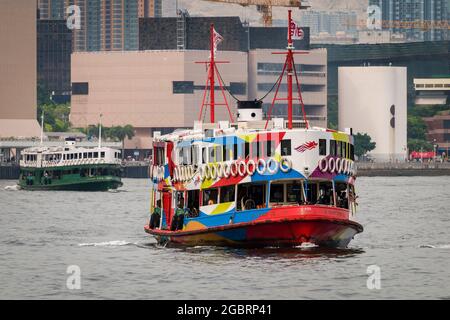 La 'Night Star', una delle flotte di Star Ferry dipinta nella livrea di Brand Hong Kong, attraversa Victoria Harbour da Tsim Sha Tsui al centro Foto Stock