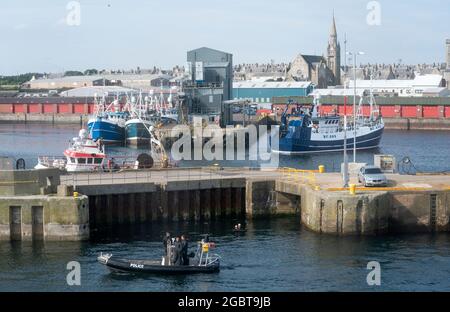 La polizia pattuglia il porto di Fraserburgh come primo ministro Boris Johnson a bordo dell'Essagt Alba durante una visita al Moray Offshore Windfarm East, al largo della costa dell'Aberdeenshire, durante la sua visita in Scozia. Data immagine: Giovedì 5 agosto 2021. Foto Stock