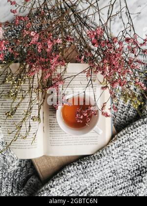 Tazza di tè con un libro e fiori Foto Stock