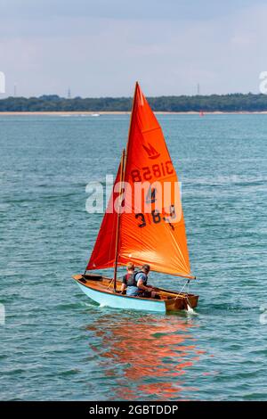 specchio vela dinghy con equipaggio fuori di cowes durante la settimana di cowes sull'isola di wight, regno unito Foto Stock