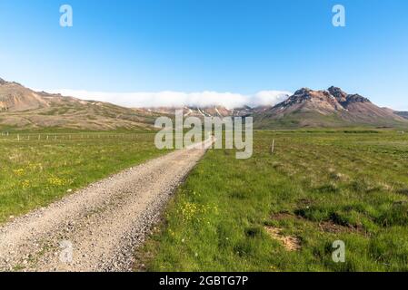 Percorso desertato attraverso i prati che conducono alle montagne in una giornata estiva limpida Foto Stock