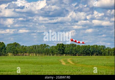 una ventosca sotto forma di cono di tessuto rosso e bianco è completamente dispiegata sul campo d'aria del campo d'aria Foto Stock