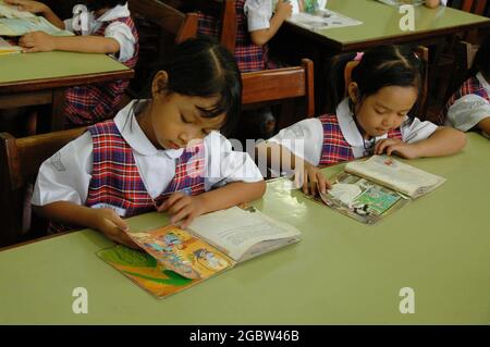 Due studenti di asilo leggono libri su un tavolo. Foto Stock