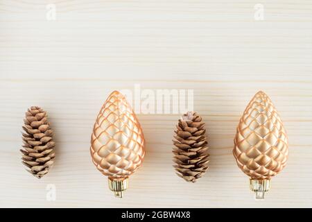 Coni di pino su sfondo di legno. Concetto opposto. Nuovo contro vecchio, naturale contro artificiale. Foto Stock