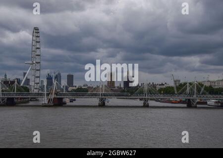 Londra, Regno Unito. 5 agosto 2021. Le nuvole scure si radunano sul London Eye, sulle Camere del Parlamento e sui ponti di Hungerford e del Giubileo d'Oro quando la pioggia ritorna nella capitale (Credit: Vuk Valcic / Alamy Live News) Foto Stock