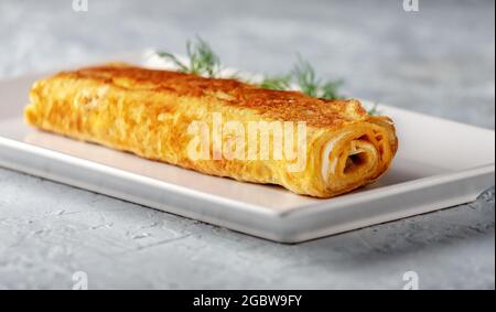 Cucina giapponese. Tamagoyaki - frittata giapponese, arrotolato diversi strati di uova fritte Foto Stock