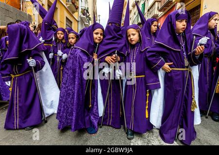 Un gruppo di bambini partecipa A UNA processione di strada, Semana Santa (settimana Santa), Malaga, Andalusia, Spagna. Foto Stock