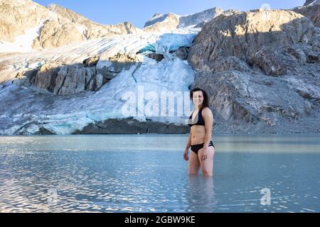 Avventurosa donna bianca caucasica Adult Swimming nel lago ghiacciato Glacier Foto Stock