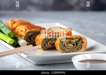 Cucina giapponese. Tamagoyaki - frittata giapponese, arrotolato diversi strati di uova fritte Foto Stock