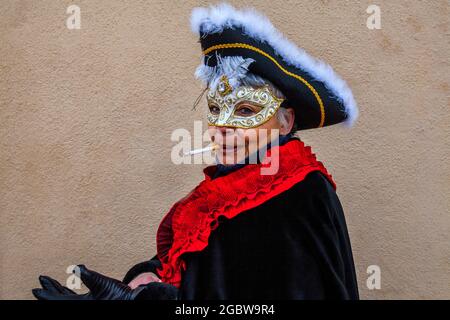 Una donna in costume Fumare una sigaretta durante il Carnevale di Venezia, Burano, Venezia, Italia. Foto Stock