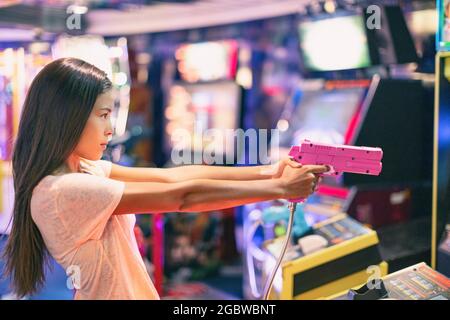 Arcade gioco macchina adulta donna sparare pistola video giochi giocare luce sparare videogioco realtà virtuale Foto Stock