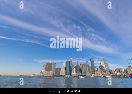 Lo Skyscraper di Lower Manhattan si erge oltre l'East River dal Brooklyn Bridge Park il venerdì mattina del 20 giugno 2021 a Brooklyn New York City. Foto Stock