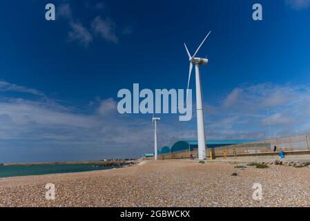Due turbine eoliche che generano elettricità su una spiaggia del West Sussex a Southwick. Foto Stock