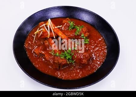 curry indiano del gambo dell'agnello cotto lento, anche conosciuto come nalli rogan josh Foto Stock