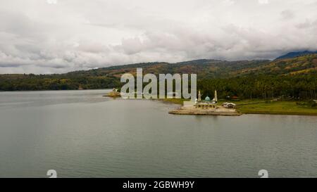 Drone aereo della Moschea e del lago Lanao circondato da montagne. Mindanao, Lanao del sur, Filippine. Foto Stock