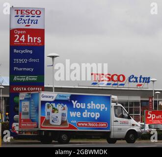 Un fan di Tesco lascia il negozio Tesco a Portsmouth. Tesco è stato vantato da attivisti verdi per aver reso le consegne a casa a 14 miglia di distanza da un supermercato piuttosto che da altri 1.5 miglia di distanza. Il gigante del supermercato, il cui motto è ‘ogni piccolo aiuto’, invia cibo a Hedge End, Hants, dal loro supermercato a Portsmouth, nonostante quello di Bursledon sia più vicino. Tesco sostiene che il loro negozio Bursledon, che dispone anche di un servizio di consegna a domicilio, è uno dei più attivi in Gran Bretagna e utilizza la filiale di Portsmouth per consegnare invece tagli alla ‘congestione’. PIC mike Walker, 2008 Foto Stock