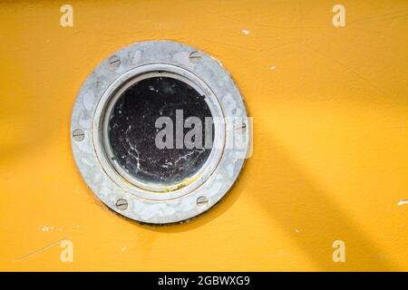 Oblò galvanizzato su una Yellow Boat England UK Foto Stock