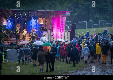 Wilderness Festival, Oxfordshire, Regno Unito. 5 agosto 2021. I festaioli godono del Wilderness Festival nonostante la pioggia, mentre l'evento inizia il suo decimo anno. E 'stato rinviato nel 2020 a causa di Covid, ma è stato in grado di Passi pure nel 2021 con rigorosi test in atto. Credit: Andrew Walmsley/Alamy Live News Foto Stock