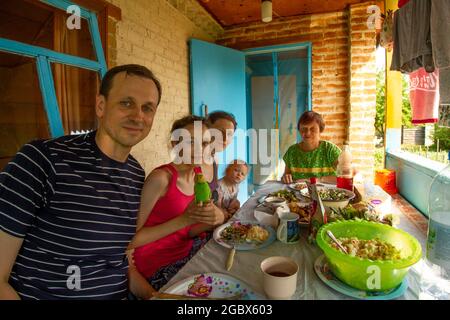 Una normale famiglia russa media celebra una piccola vacanza tradizionale in una casa colonica di campagna. Foto Stock