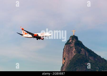 RIO DE JANEIRO, BRASILE - 26 FEBBRAIO 2016: L'aereo di Gol Airlines sta volando verso la statua del Cristo Redentore sul monte Corcovado. Foto Stock