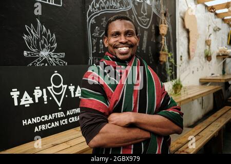 Il proprietario di affari sudafricano, Tapiwa Guzha, nella sua gelateria chiamata TAPI TAPI. TAPI TAPI è un ideofono bantu che significa dolce. Foto Stock