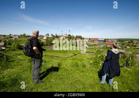 I turisti ammirano la vista del villaggio di Nyonoksa e templi in legno Foto Stock