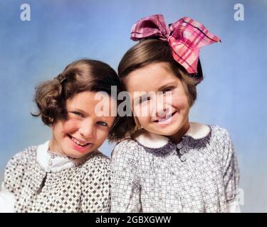 1920 RITRATTO DEGLI ANNI '30 DUE RAGAZZE SORRIDENTI TESTA A TESTA GUARDANDO LA FOTOCAMERA - J4453C HAR001 HARS ESPRESSIONI OCCHIO CONTATTO FELICITÀ TESTA E SPALLE SORRISO ALLEGRO GIRLFRIENDS GIOIOSO ELEGANTE ETNIA CAUCASICA HAR001 VECCHIO STILE Foto Stock