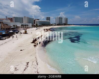 Cancun, Quintana Roo, Messico, 12 giugno 2020.- lavoratori pulire sargassum su una spiaggia a Cancun, la macchia di sargassum può essere visto dall'aria. Foto Stock