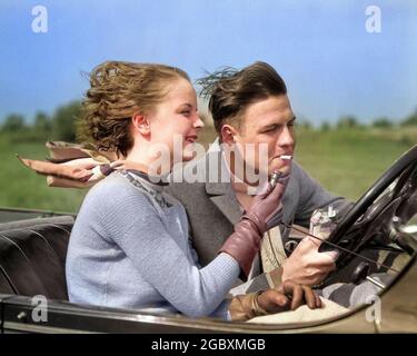 UOMO DEGLI ANNI '30 CHE GUIDA AUTO CONVERTIBILE, MENTRE LA RAGAZZA ACCENDE LA SUA SIGARETTA - T3286C HAR001 HARS MAGLIONE NOSTALGICO AZIONAMENTO ELETTRICO COPPIA ATTIVA ROMANTICISMO GUANTO SUBURBANO COLORE AZIONE VELOCE RELAZIONE SIGARETTA CONVERTIBILE VECCHIO TEMPO CORSA NOSTALGIA VECCHIO MODO AUTO CAMPAGNA SKYLINE GIOVANILE PAURA VEICOLO AMICO GIOVANE ADULTO SICUREZZA VACANZA SELVAGGIO STILE DI VITA VELOCITÀ SPOSATA RELAZIONE RURALE CONIUGE TRASPORTO COPIA SPAZIO AMICIZIA ADOLESCENTE MATRIMONIO AUTOMOBILE BOYFRIEND DANGER AMERICANA TRASPORTO PARTNER SIGARETTE RAGAZZA STUPIDA TENTAZIONE ATTIVITÀ DISASTRO FUMATORI TESTA E SPALLE AVVENTURA Foto Stock