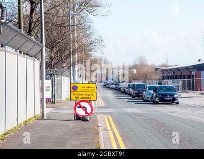 Linea di veicoli in coda per entrare nel sito locale di raccolta rifiuti domestici durante la covid 19 restrizioni di blocco sistema di accesso a una sola via in funzione Foto Stock