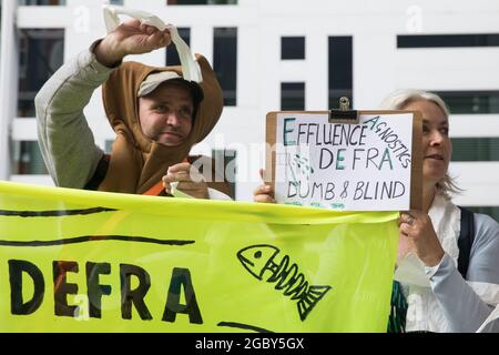 Londra, Regno Unito. 5 agosto 2021. Estinzione attivisti della ribellione protestano fuori dal Dipartimento per l'ambiente, l'alimentazione e gli affari rurali (Defra) contro l'inquinamento dei corsi d'acqua del Regno Unito. Gli attivisti hanno messo in evidenza l'inquinamento dei fiumi da parte di aziende e aziende idriche e l'incapacità dell'Agenzia per l'ambiente e di Defra di proteggere i corsi d'acqua e di perseguire i colpevoli. Credit: Mark Kerrison/Alamy Live News Foto Stock