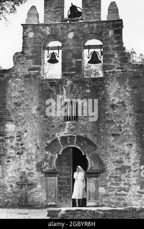 San Antonio Texas USA, circa 1990: Nun in abitudine esce dal santuario a Mission San Jose, una delle quattro missioni spagnole che fa parte del San Antonio Missions National Historical Park e il più grande del sentiero delle chiese che segue il fiume San Antonio a sud dal più noto Alamo. ©Bob Daemmrich Foto Stock