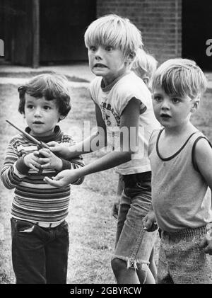 Bryan Texas USA, circa 1978: I giovani ragazzi reagiscono dopo che il giocattolo stavano giocando con Hit una finestra vicina. ©Bob Daemmrich Foto Stock