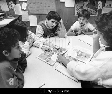 Austin Texas USA, circa 1993: Insegnante di scuola elementare femminile che lavora con studenti di terza classe inglese come seconda lingua (ESL). ©Bob Daemmrich Foto Stock