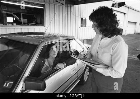 Austin Texas USA, circa 1991: La scrittrice del reparto assistenza presso il negozio di riparazione auto chiede al cliente problemi con la sua auto. No MR Foto Stock