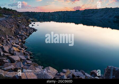 Piccolo lago circondato da rifiuti di pietra provenienti da lavori minerari Foto Stock